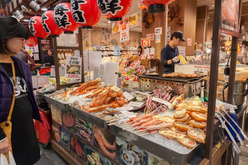 Osaka Kuromon Market Vendor With Yakitori And Kushiyaki Skewers Of Meat
